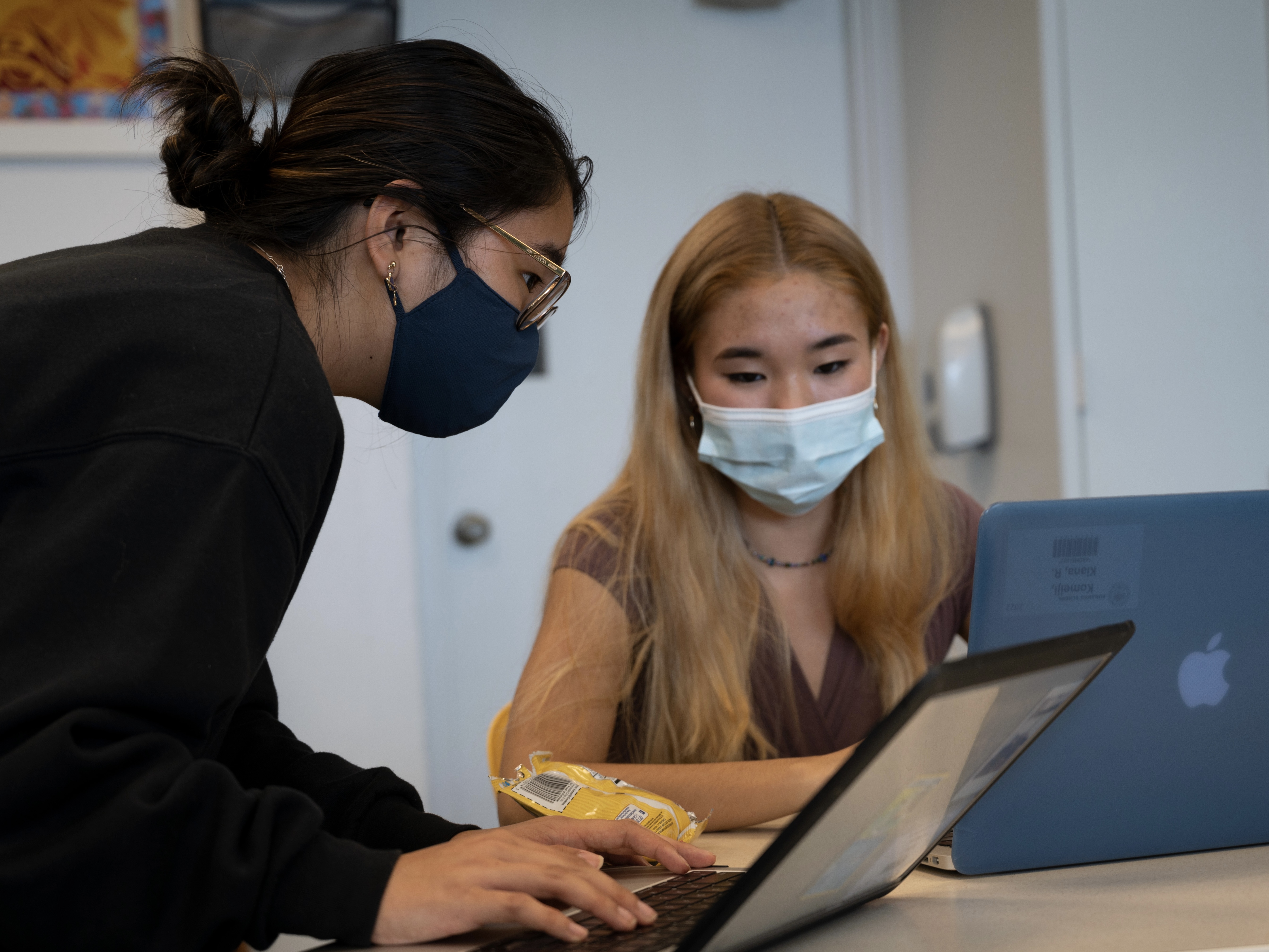 two girls working on code together and collborating